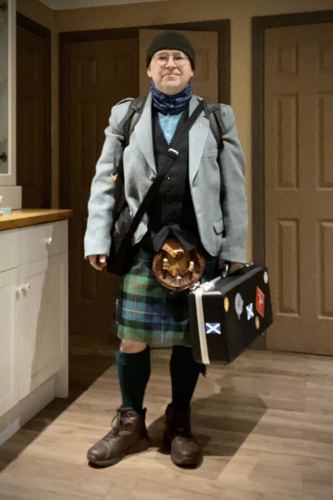 Me about to depart my house, wearing the kilt, rucksack on my back and pipe case in my hand